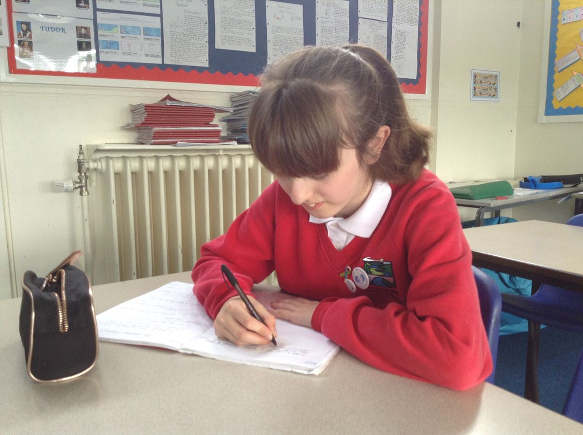 Young girl writing at school