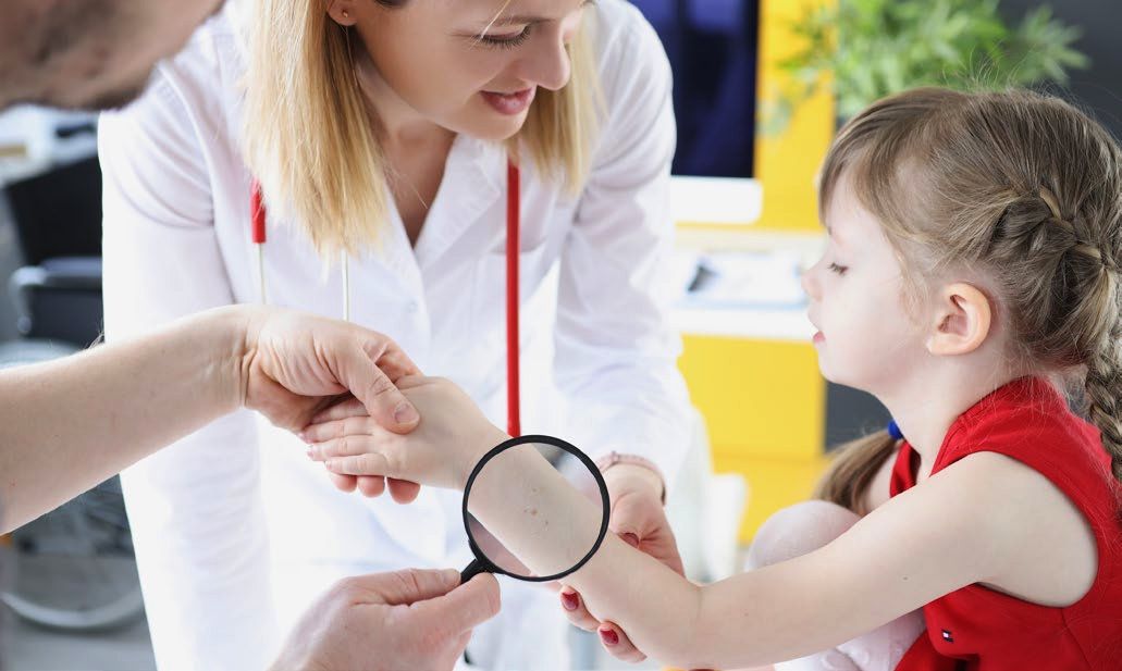 Doctor examining a child's skin for NF1 with a magnifying glass